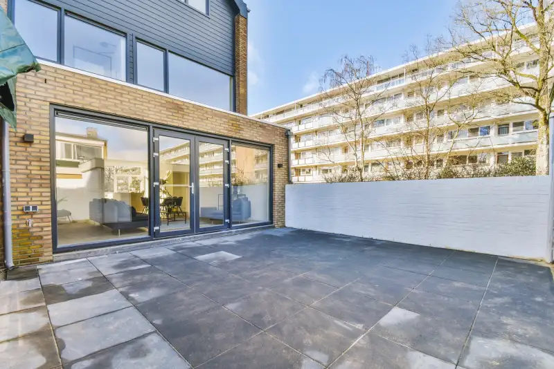 Bestrating — achtertuin met grote antraciet betontegels