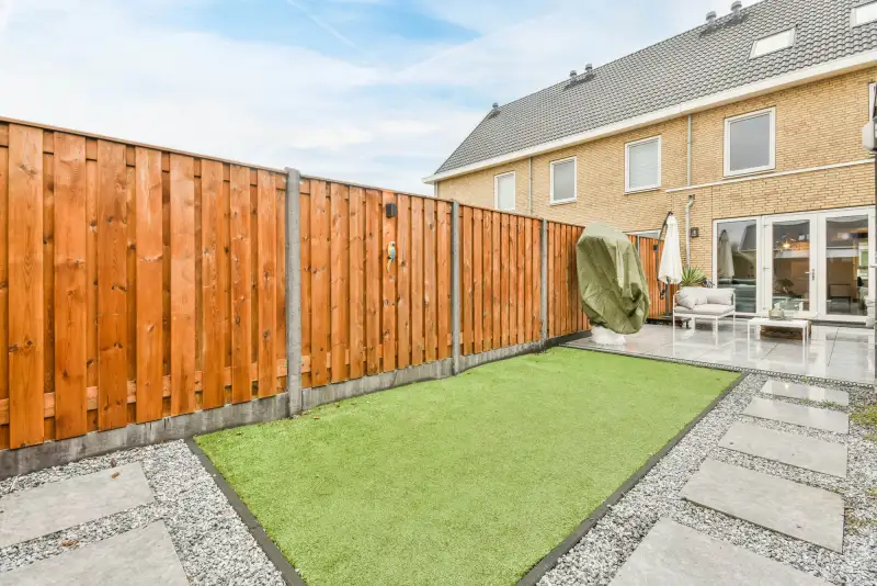 Nette achtertuin met hout-betonschutting en gazon