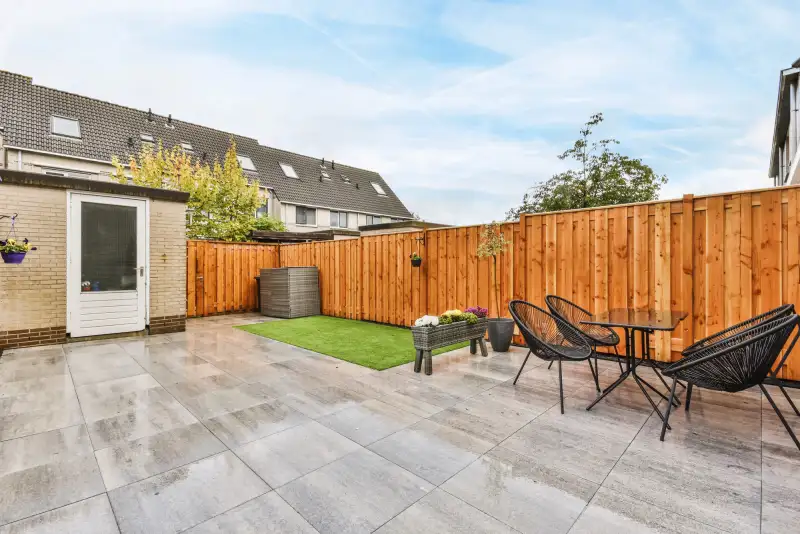 Tuinaanleg — nieuw aangelegde achtertuin met bestrating en schutting