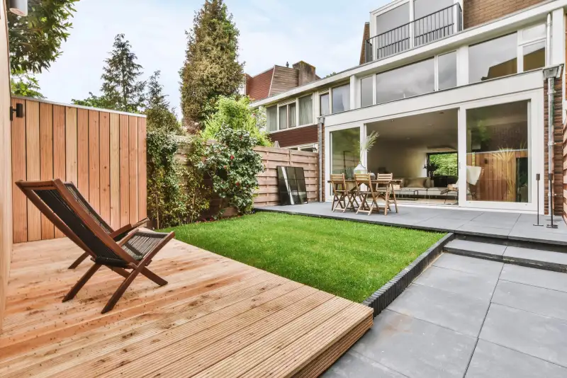 Vakkundig aangelegde tuin met houten vlonder, gazon en terras