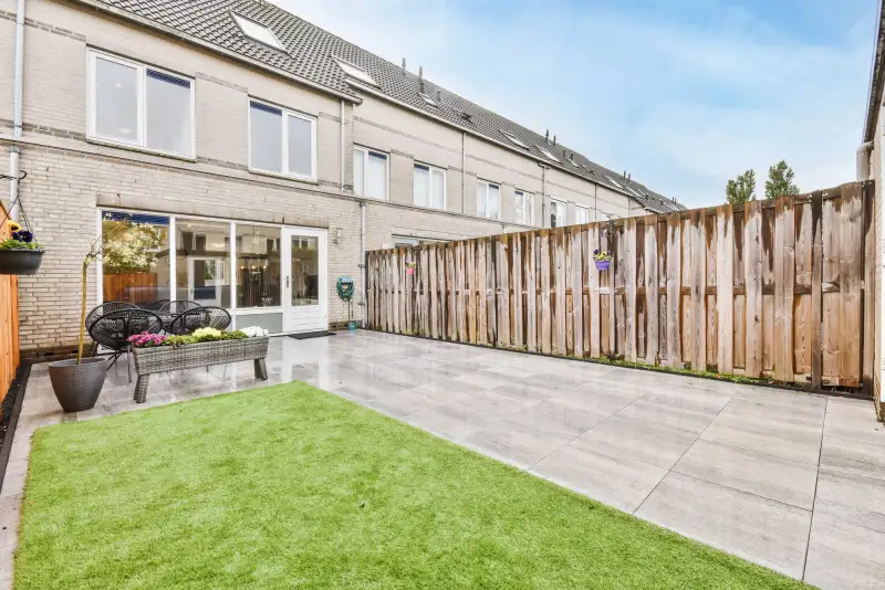 Tuinrenovatie — gerenoveerde achtertuin met sierbestrating en gazon